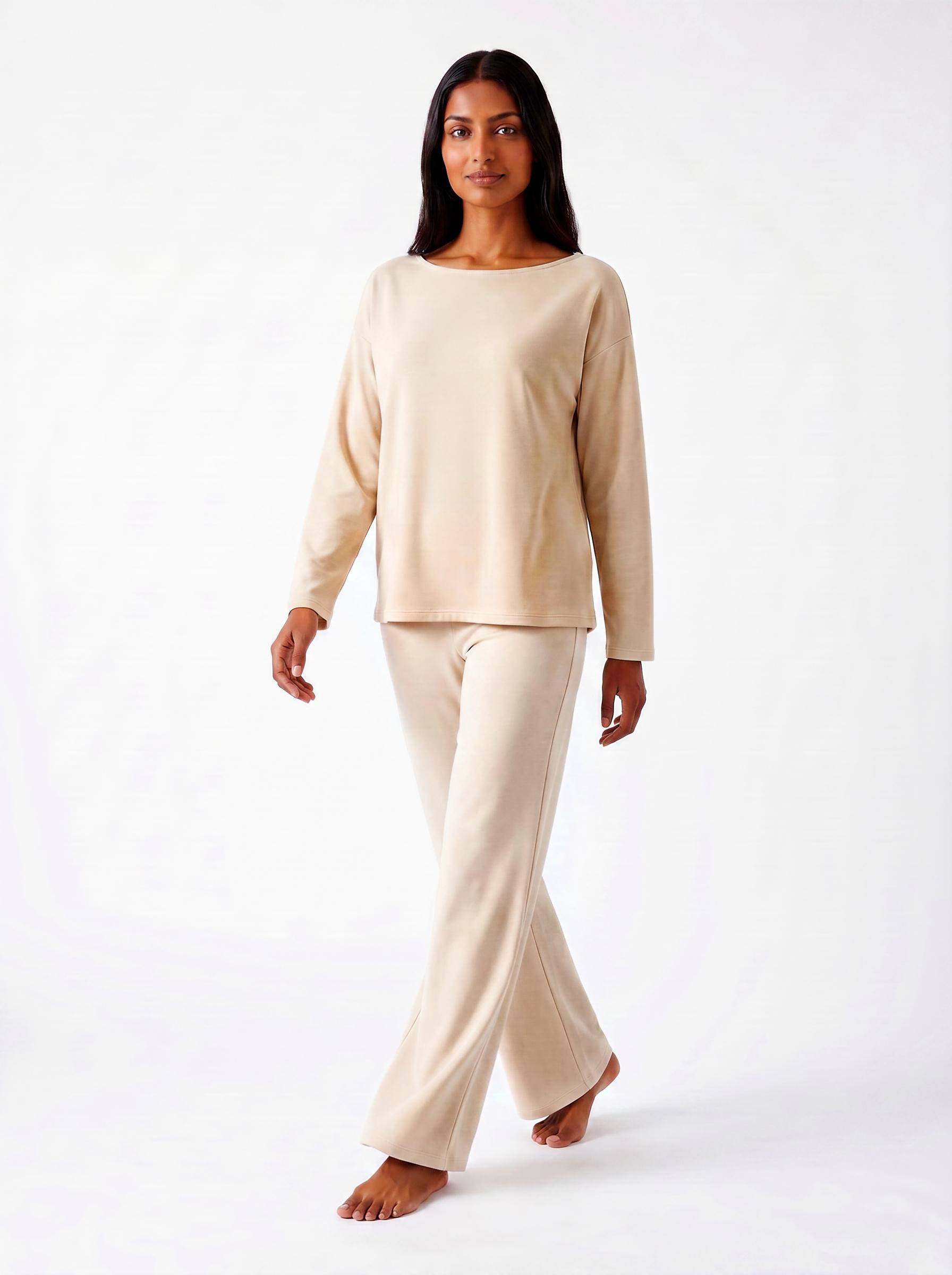 Woman wearing a warm bone bamboo loungewear set on a white background