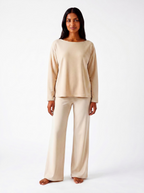 Woman wearing a warm bone bamboo loungewear set on a white background