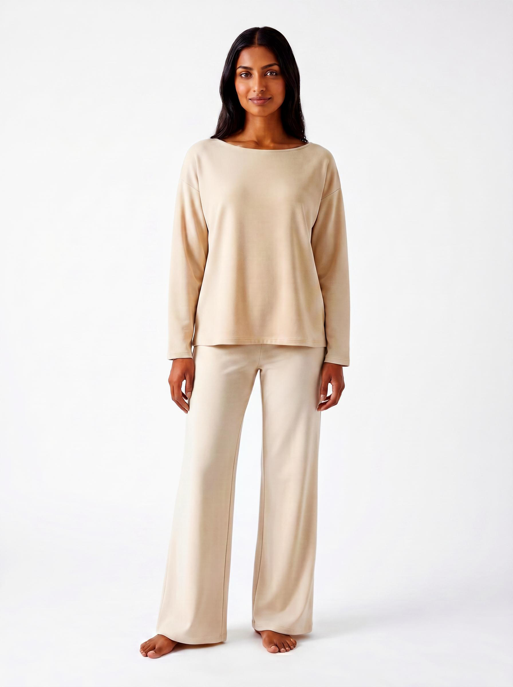 Woman wearing a warm bone bamboo loungewear set on a white background